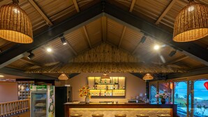 A bar area with a counter, stools, and a refrigerated display. - The Linh Seaside Villa Hoi An (Da Nang)