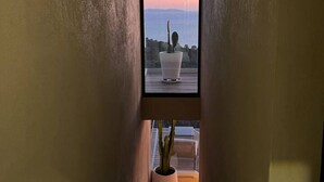 A staircase leading to a balcony with a potted plant and a view of the sea. - Large 2-room apartment with panoramic sea view (Rayol-Canadel-sur-Mer)