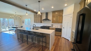 Una cocina moderna con una isla grande, armarios de madera y un horno empotrado.