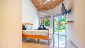A bedroom with a bed, a heart-shaped decoration, a ceiling fan, and a window with a view of greenery. - Two bedroom. Ojochal. Private pool. Minutes to beach (Ojochal)