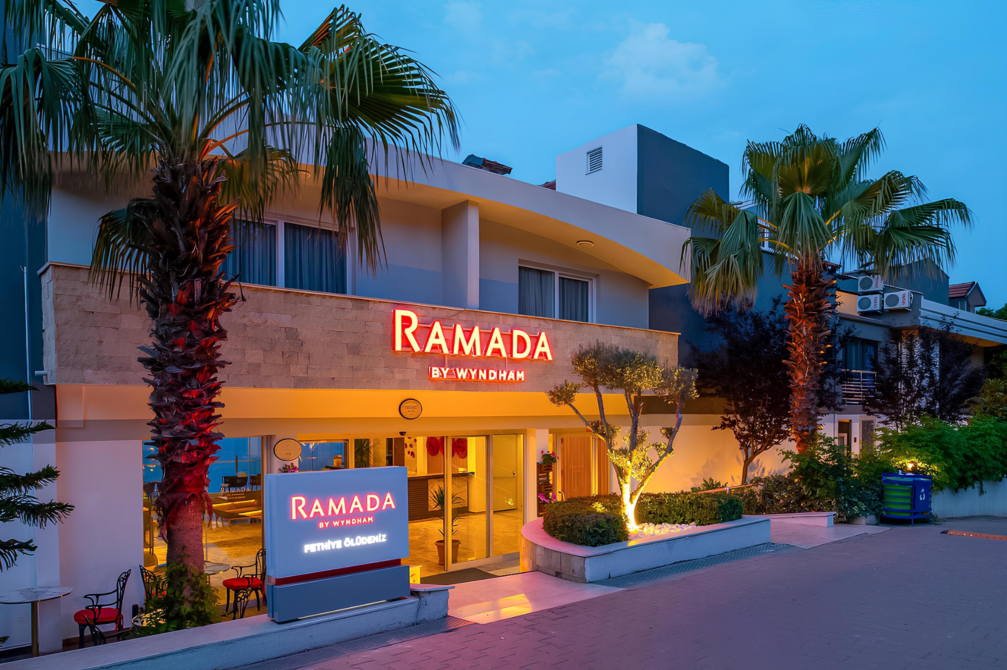 A modern building with a sign reading "RAMADA BY WYNDHAM".