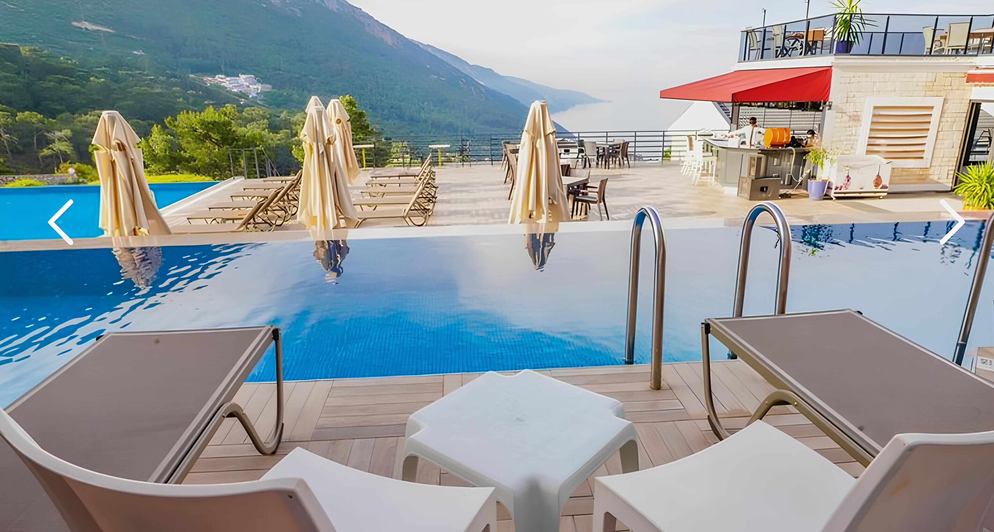 A pool area with lounge chairs, umbrellas, and a bar.