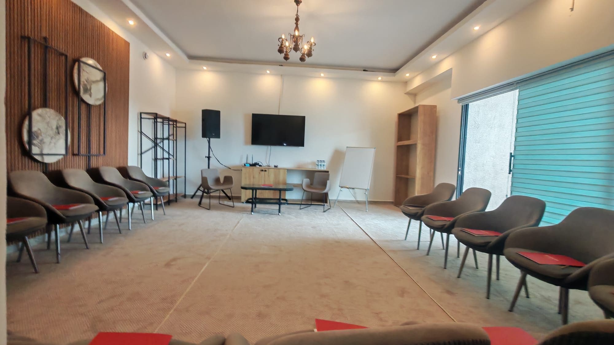 A conference room with a long table, chairs, a TV, and a whiteboard.