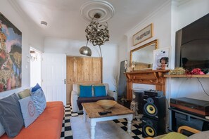 Apartamento básico, varias camas | Zona de estar | Una televisión