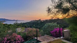 A scenic view of a coastal landscape with a fence and flowering plants. - Le Repaire des Pirates (Pietrosella)