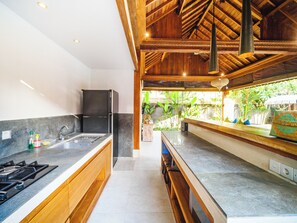 Kjøleskap, kokeplater, kjøkkenutstyr og spisebord