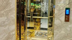 Un ascenseur doté d’un intérieur réfléchissant et d’un motif décoratif sur le sol.