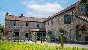 A stone building with a sign reading "Queens." - The Queen's Chew Magna (Bristol)
