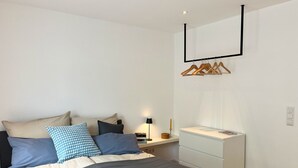 Une chambre à coucher moderne avec un lit, une table de chevet et une commode.