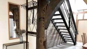 A modern interior with a wooden staircase, a mirror, and a small table with a vase. - *Schwarzwald-Haus mit Sauna* (Elzach)
