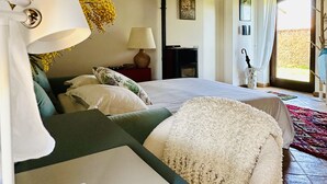 A bedroom with a bed, a desk with a laptop, a lamp, and a window with curtains. - Milva's Nest Countryside (Umbria)