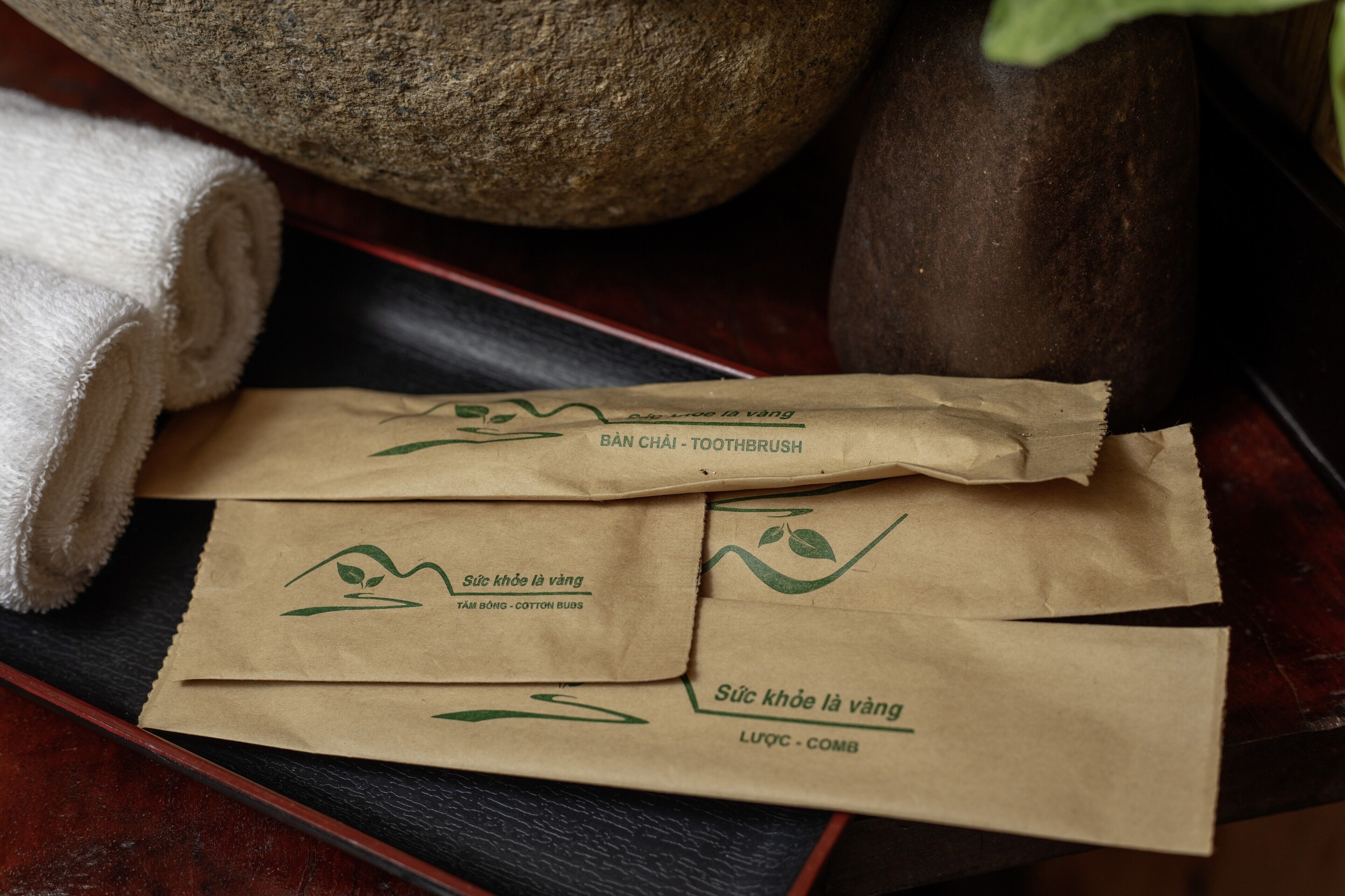 A tray with paper bags labeled "Súc khối là vương" and "TAM BỘNG - COTTON BUDS".