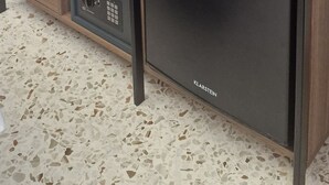 Uma cozinha moderna com máquina de lavar louça embutida, armários de madeira e bancada.
