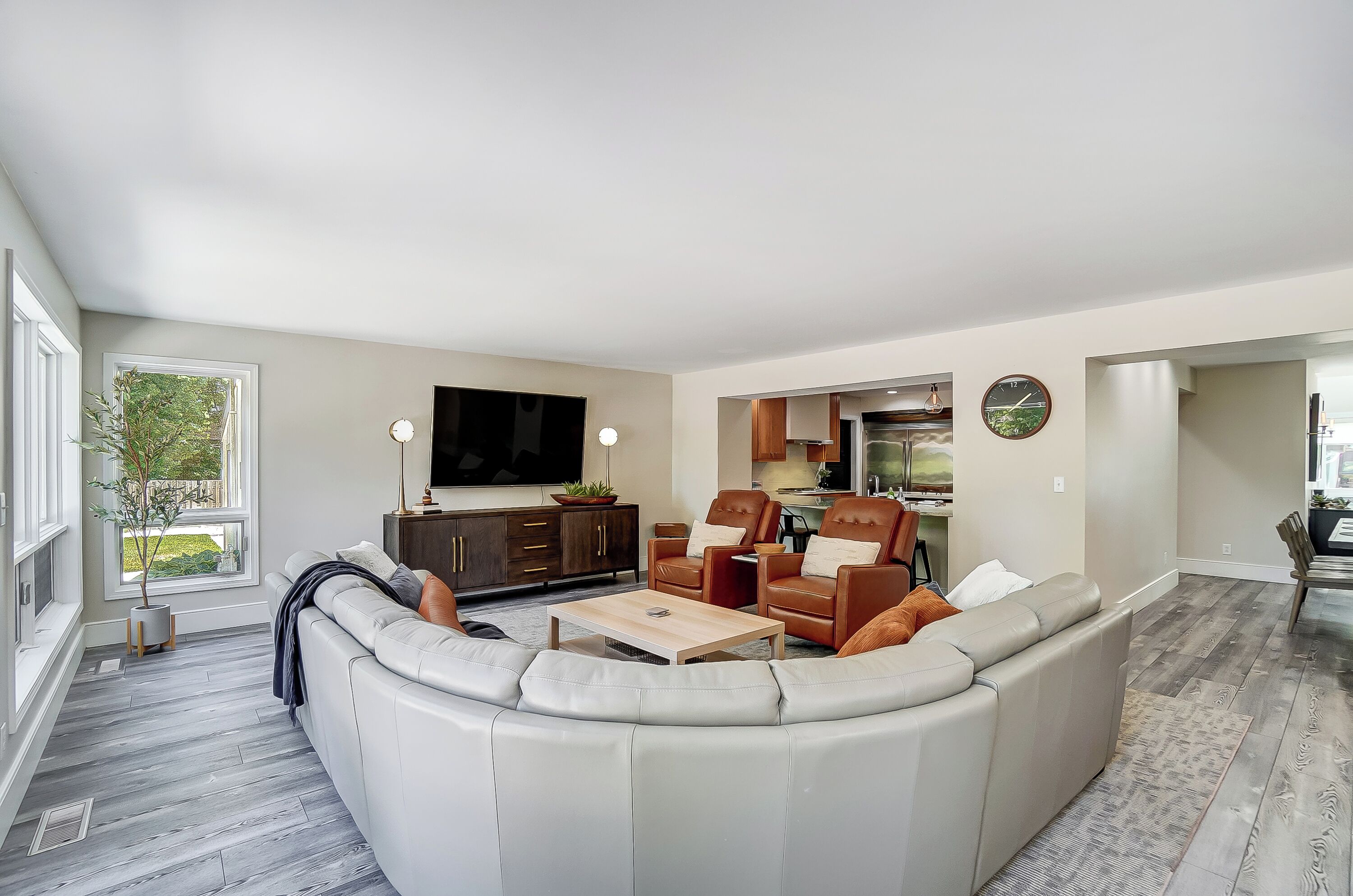 A modern living room with a sectional sofa, a coffee table, and a TV.