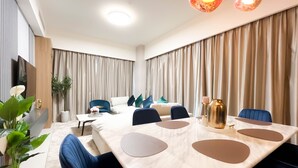 A modern hotel room with a large bed, a desk, and a dining area with a marble table. - Luxury Burj Royale Full Burj Khalifa & Fountain Views (Dubai)