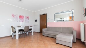 Una sala de estar moderna con comedor, un sofá y una mesa de centro.