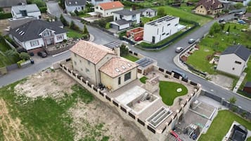 An aerial view of a residential area with houses, a large open space, and a swimming pool.