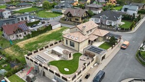 An aerial view of a residential area with houses, a swimming pool, and a road.