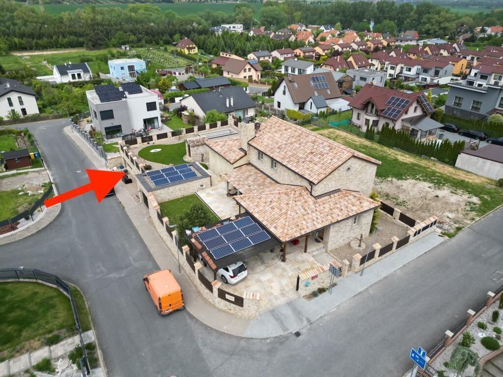 Luchtbeeld van een woongebied met huizen, wegen en een zonnepaneelinstallatie op een huis.