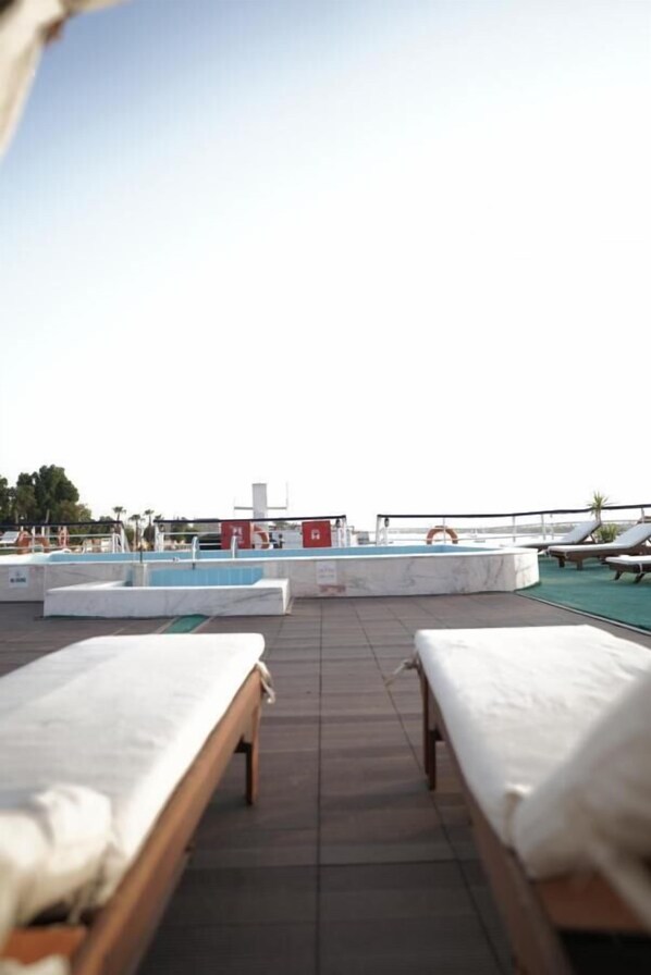 Alberca al aire libre, sombrillas en la alberca y camastros 