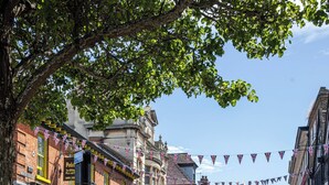 A cobblestone street lined with historic buildings, some with green awnings and flower boxes. - Castle Garden View - Two Steps from Central Rochester High Street (Rochester)