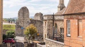 A historic stone building with a brick extension, a stone wall, and a red car parked in front. - Castle Garden View - Two Steps from Central Rochester High Street (Rochester)