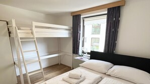 A room with a bunk bed, a desk, and a window with curtains. - Apartment Zachary (Kaprun)