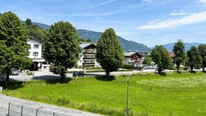A residential area with houses, a grassy field, and mountains in the background. - Apartment Zachary (Kaprun)