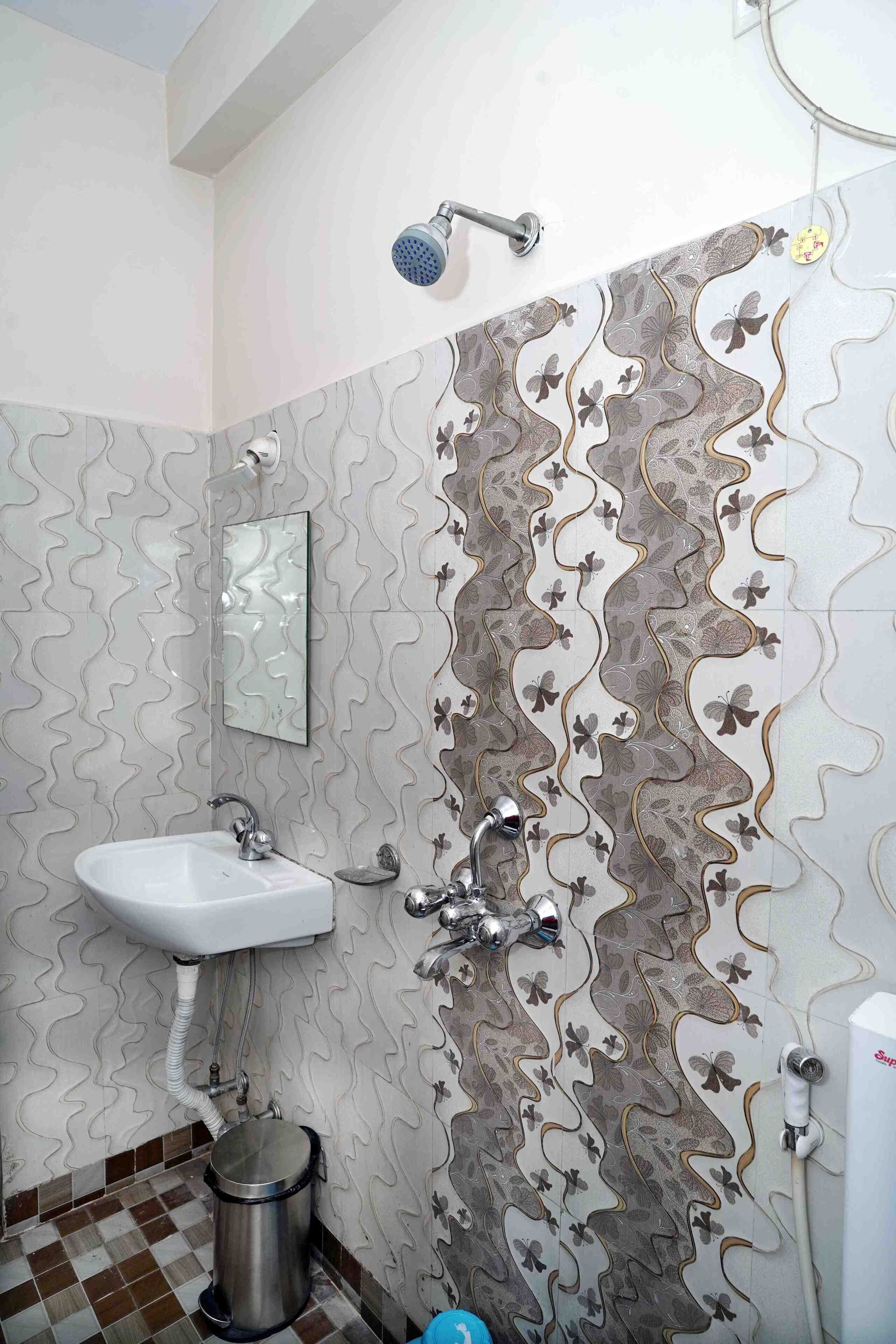 Ein Badezimmer mit Waschbecken, Spiegel, Dusche und fliesenmuster
