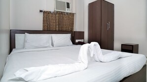 A neatly made bed with white linens and a towel arranged in a bow shape on the bed. - Sonar Bangla Guest House (Kolkata)