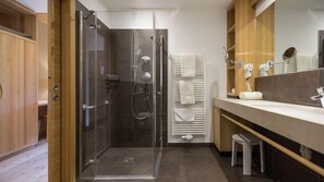Un bagno moderno con doccia vetrata, lavabo con specchio e portasciugamani.
