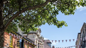 A cobblestone street lined with historic buildings, some with green awnings and flower boxes. - Castle Garden View - Two Steps Away from Central Rochester High Street (Rochester)