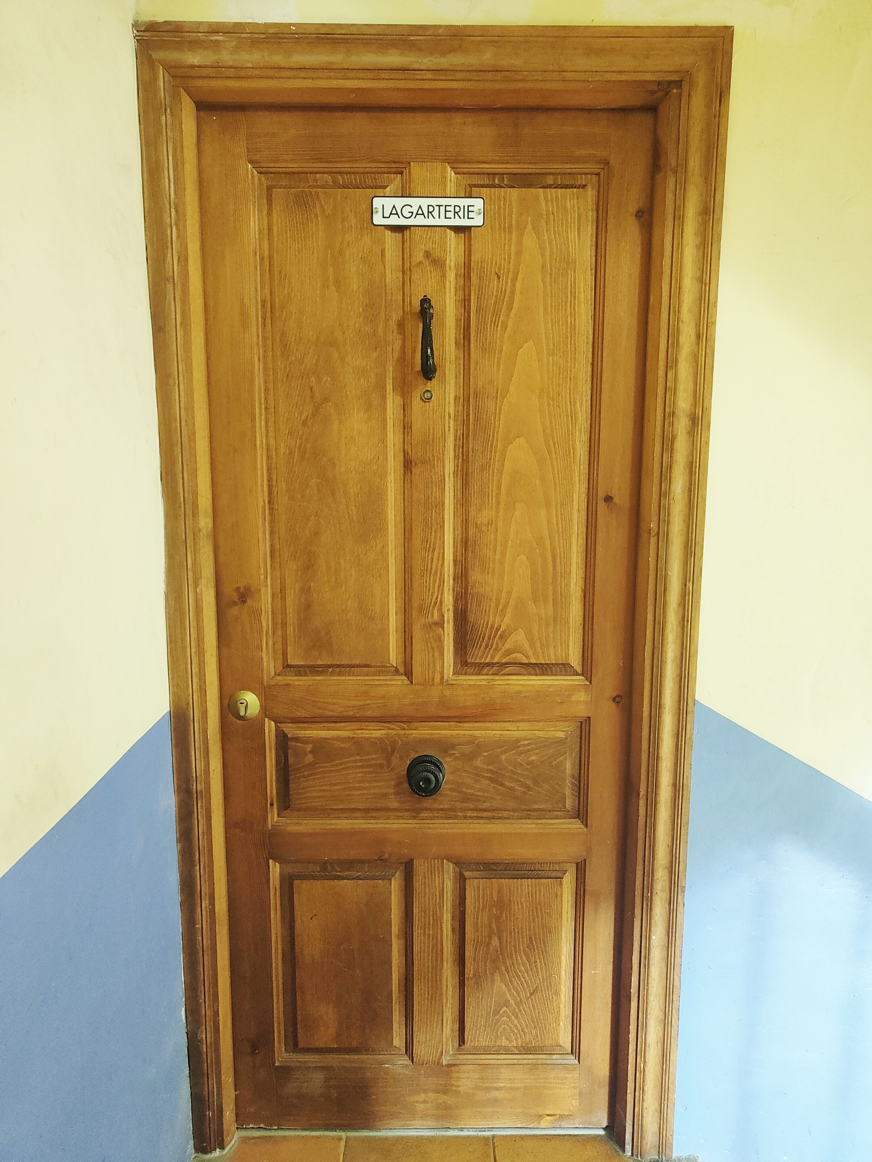 Una porta di legno con un cartello che riporta la scritta "LAGARTERIE".