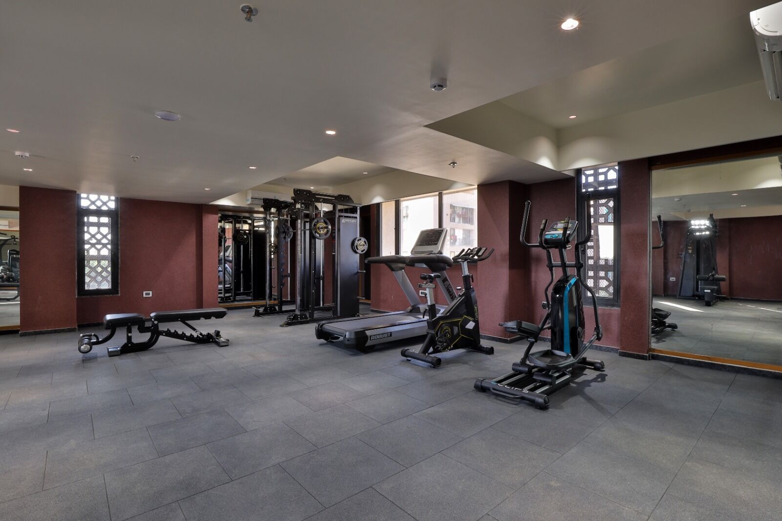 Ein Fitnessstudio mit Laufbändern, Crosstrainern und Gewichten.