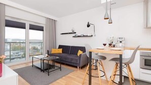A modern living room with a sofa, coffee table, and dining area.