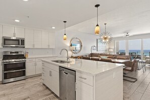 Een moderne keuken met roestvrijstalen apparatuur, een centraal eiland en een eetgedeelte met uitzicht.