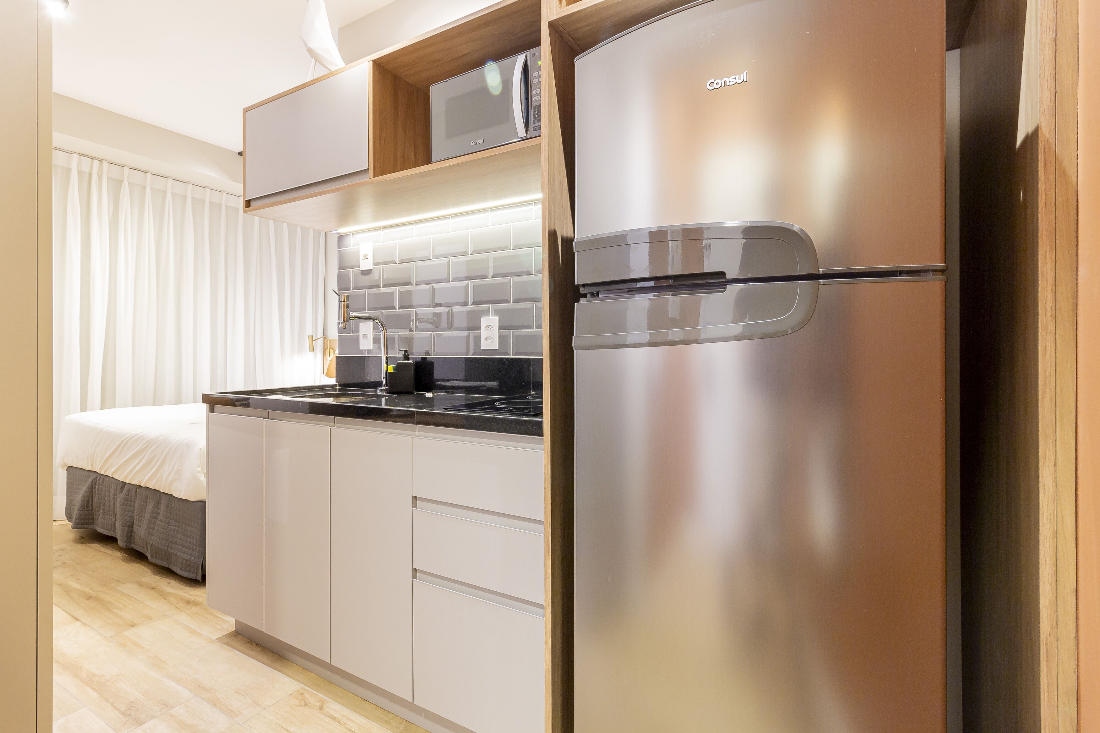 A modern kitchen with a stainless steel refrigerator, a microwave, and a built-in oven.