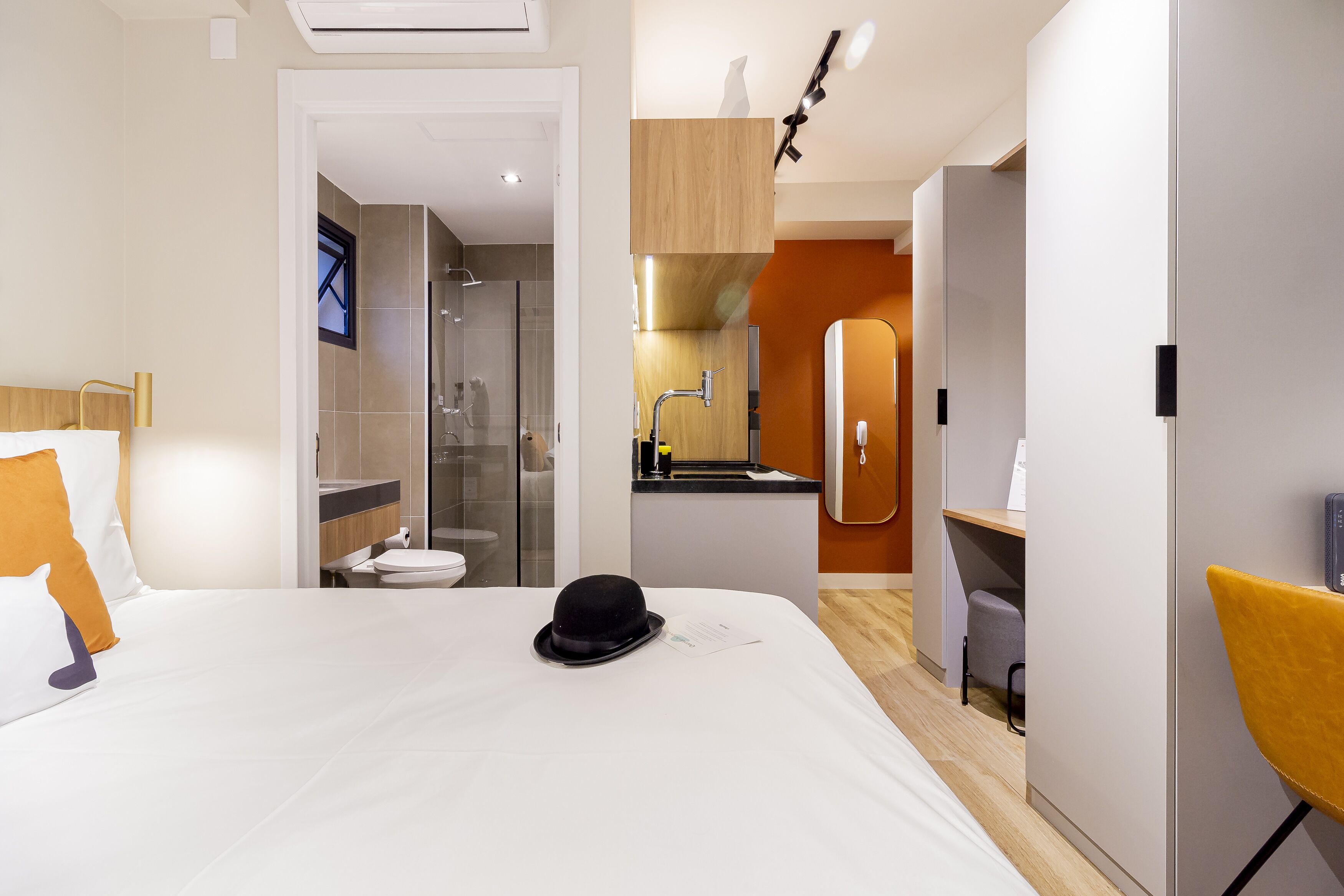Et moderne hotelværelse med seng, badeværelse og et lille tekøkken.