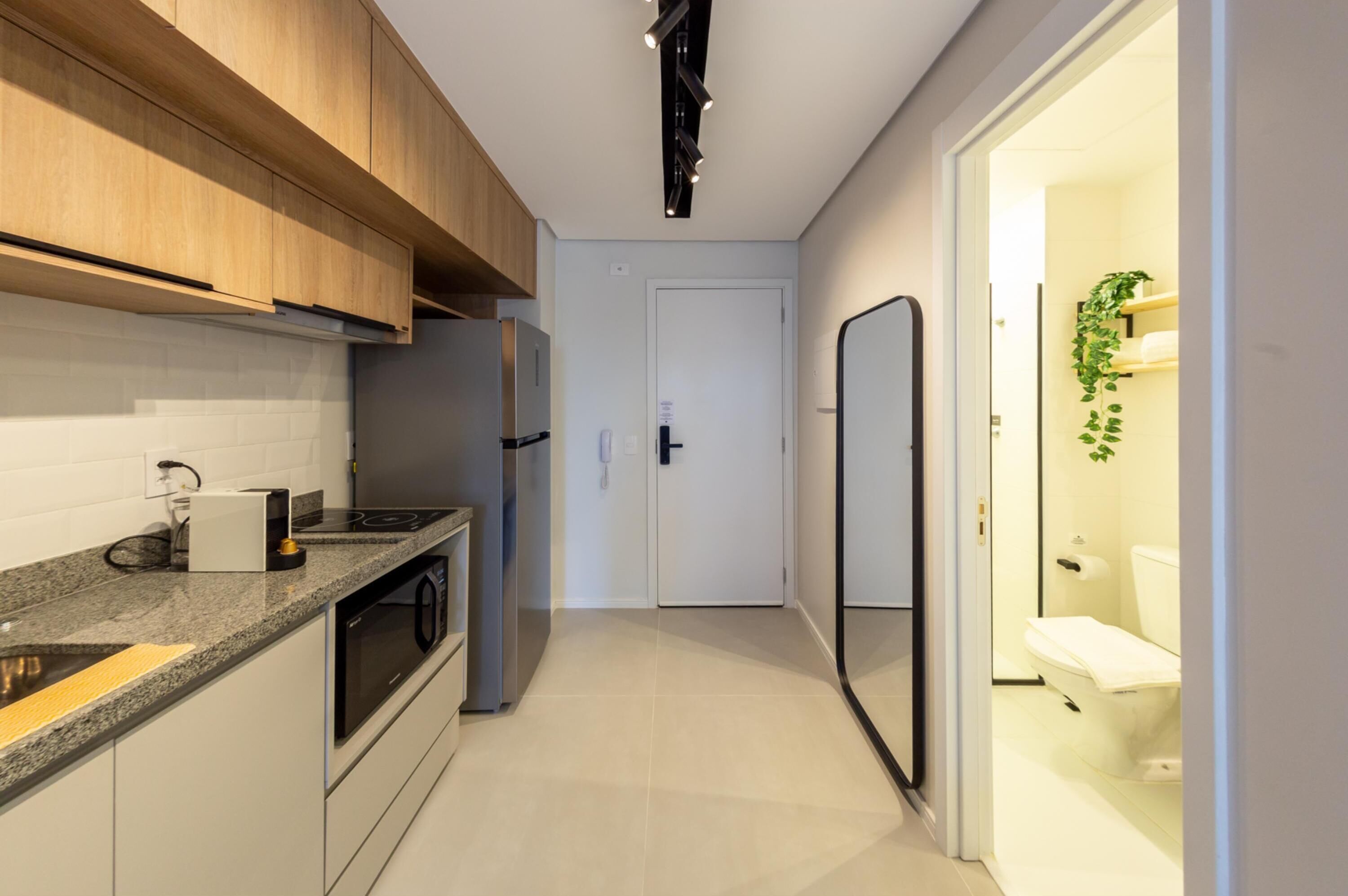 A modern kitchen with wooden cabinets, a built-in oven, and a countertop with a coffee maker.