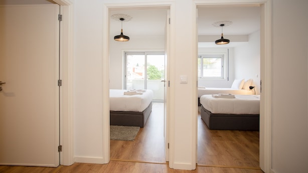 Un dormitorio moderno con dos camas, un ventanal y vistas al exterior.