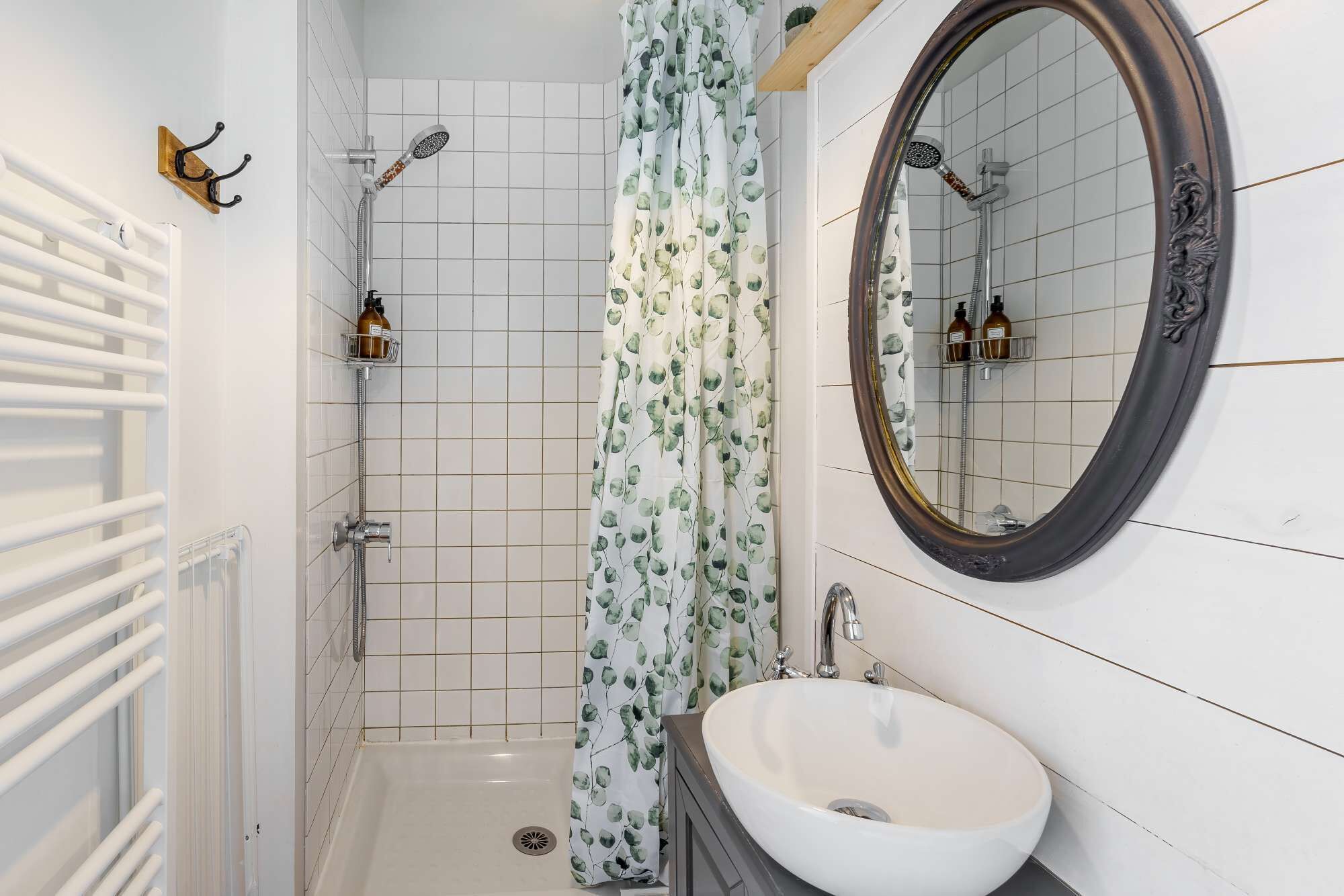 Ein Badezimmer mit einer weißen Badewanne, einer Dusche, einem Waschbecken und einem Spiegel.