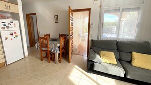 Un espacio habitable compacto con kitchenette, comedor y sofá.