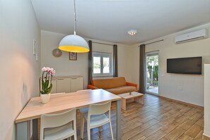 Relax in this stylish living space with a dining area, seating, and a large window.