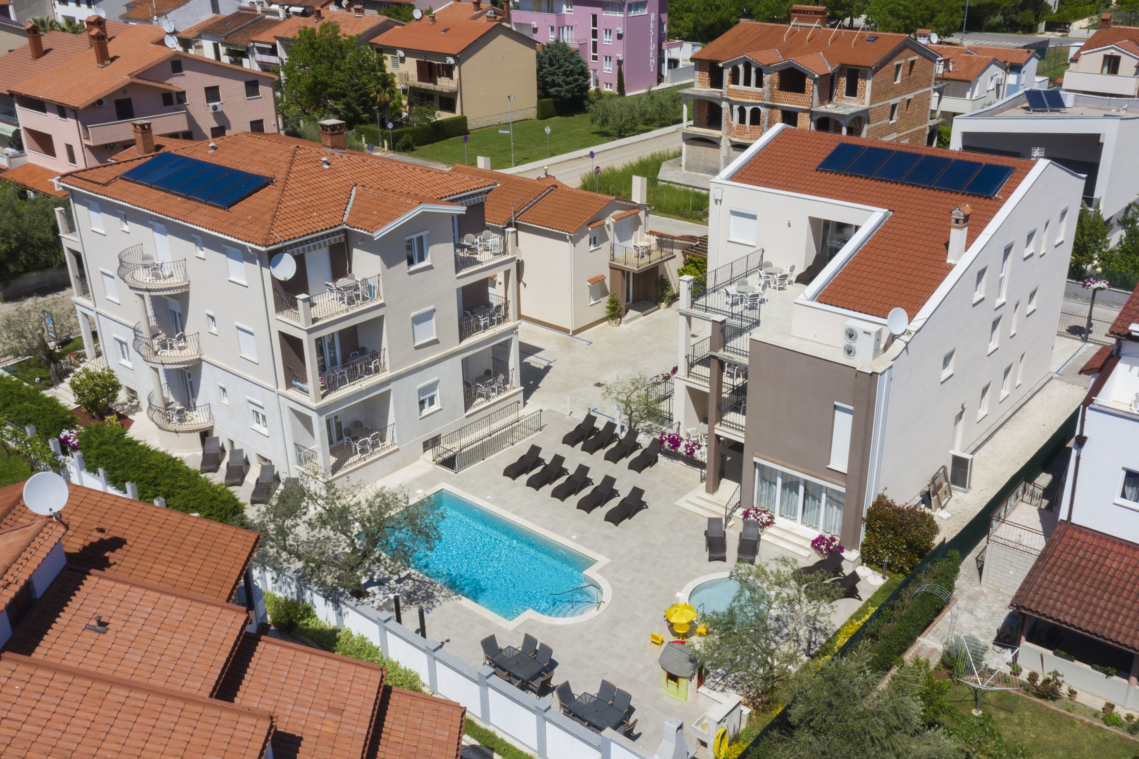 A residential building with a rooftop pool, balconies, and solar panels.