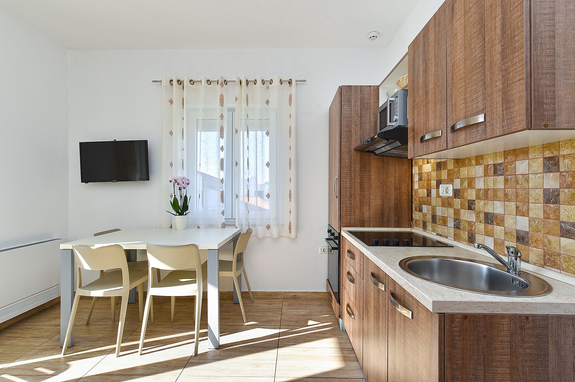 Una cucina moderna con mobili in legno, forno a incasso e un lavello capiente.