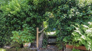 A stone staircase surrounded by lush greenery and potted plants. - The Stables (Colne)