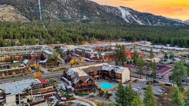 A resort area with multiple buildings, a swimming pool, and a mountainous backdrop. - Exquisite Stateline Resort, Hot Tub Zalanta #222 (South Lake Tahoe)