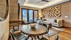 A modern living room with a fireplace, a round dining table, and a sofa. - Exquisite Stateline Resort, Hot Tub Zalanta #222 (South Lake Tahoe)
