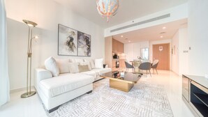 A modern living room with a white sofa, a coffee table, and a floor lamp.