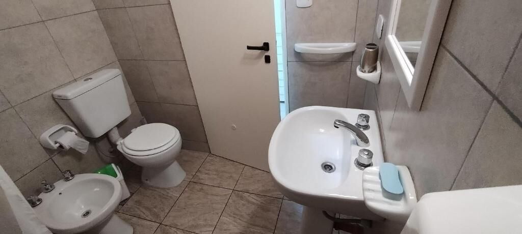 A compact bathroom with a toilet, bidet, and sink.